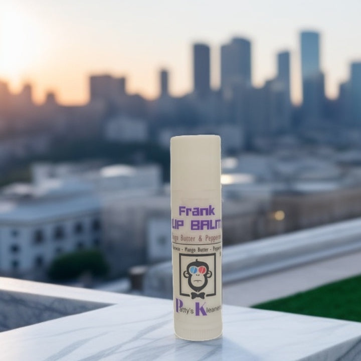 Lip balm peppermint tube with 'FRANK' Pattys Kleaners branding against a cityscape background