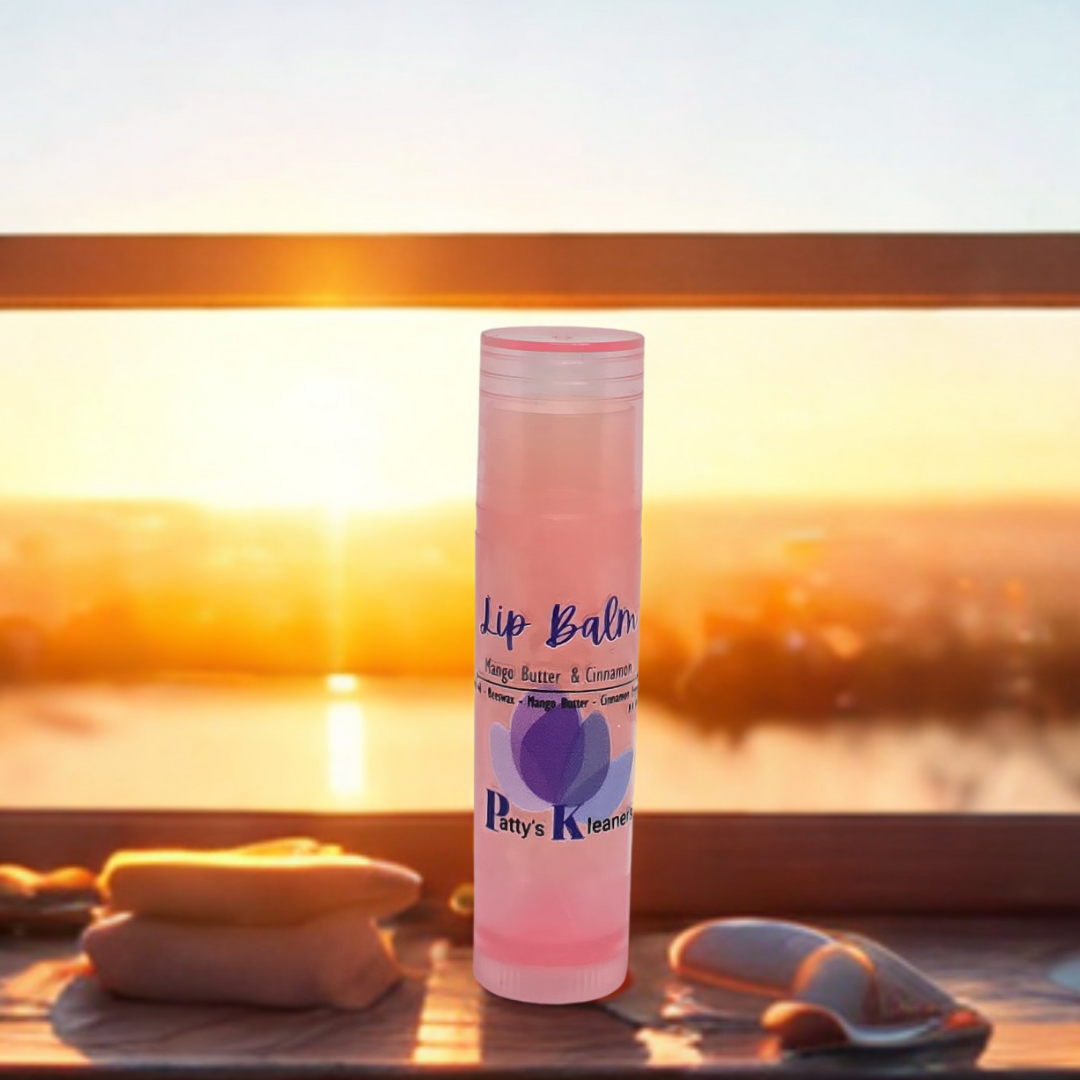 Pattys kleaners in a pink tube. Mango Butter and Cinnamon sitting in a window with a sunset behind